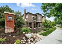 Attractive two-story townhome featuring brick exterior, manicured landscaping, and welcoming front entrance at 681 W Burgundy St # A, Highlands Ranch, CO 80129