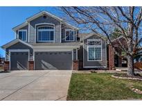 Charming gray two-story home with a well-manicured lawn, two-car garage, and appealing curb appeal at 7087 Sapphire Pointe Blvd, Castle Rock, CO 80108