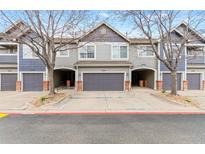 Charming townhome showcasing a well-maintained facade with attached garages and neat landscaping at 1461 S Danube Way # 104, Aurora, CO 80017