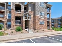Beautiful condo complex exterior featuring stone accents and well-maintained landscaping at 1425 Blue Sky Cir # 15-107, Erie, CO 80516