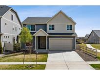 Charming two-story home featuring a large front yard, attached two car garage and inviting front porch at 5352 Truckee St, Denver, CO 80249