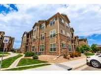 Attractive condo exterior with stone accents, multiple windows, and well-maintained landscaping at 9185 Wilde Ln # 101, Parker, CO 80134