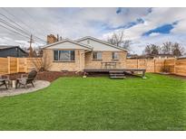 Well-maintained backyard featuring a deck, artificial grass and a firepit area at 8105 W 62Nd Ave, Arvada, CO 80004