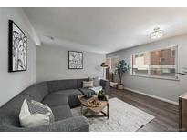 Bright living room featuring a gray couch, modern art, and wood floors at 855 N Pennsylvania # 207, Denver, CO 80218