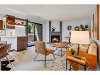 Cozy living room with a fireplace, stylish furniture, and a sliding door to the outside at 8378 S Upham Way # A102, Littleton, CO 80128