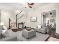 Bright living room features hardwood floors, stairs, ceiling fan and a seamless transition to the dining area at 1020 Kalamath St, Denver, CO 80204