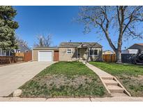 Charming single-story home featuring an attached garage, well-maintained lawn and concrete walkway to the front door at 1480 S Osceola St, Denver, CO 80219