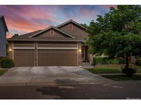 Charming home with a three-car garage, lush landscaping, and a warm, inviting entrance at 5660 S Eaton St, Littleton, CO 80123