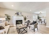 Inviting living room features a brick fireplace, neutral decor, and an open layout with modern flooring at 3750 S Fairplay Way, Aurora, CO 80014