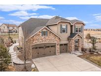 Charming two-story home featuring a stone and stucco facade, attached garage, and well-manicured landscaping at 2627 Hillcroft Ln, Castle Rock, CO 80104