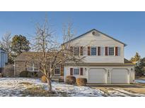Charming two-story home featuring a combination of brick and vinyl siding and a well-maintained front yard with mature trees at 7009 S Forest Ct, Centennial, CO 80122