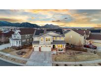 Inviting two-story home featuring a three-car garage, covered porch, solar panels, and mountain views at 19973 W 94Th Ln, Arvada, CO 80007