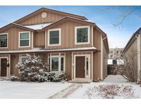 Inviting two-story home featuring a cozy bay window and a well-maintained front yard with some snow at 2145 S Lincoln St, Denver, CO 80210
