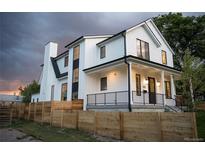 Stunning modern farmhouse exterior with a black-trimmed white facade and a charming wood fence at 3019 Chase St, Wheat Ridge, CO 80214