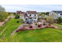 Lawn, landscaping, and a built-in stone fire pit make this backyard a welcoming outdoor living space at 42225 Kingsmill Cir, Elizabeth, CO 80107