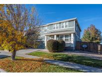 Charming two-story home with a covered porch and a well-maintained front yard on a beautiful day at 4797 Longs Peak St, Brighton, CO 80601