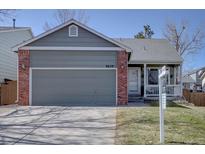 Charming single-Gathering home featuring a grey facade, brick accents, and a two-car garage at 9659 Autumnwood Pl, Highlands Ranch, CO 80129