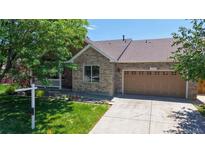 Charming single-Gathering home featuring a brick facade, attached garage, and well-manicured lawn at 1936 E 144Th Dr, Thornton, CO 80602