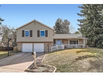 Charming two-story home featuring a well-manicured lawn, brick accents, and a welcoming front porch at 7298 S Xanthia Way, Centennial, CO 80112