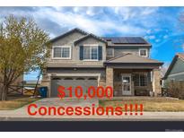 Charming two-story home featuring solar panels, a well-kept lawn and a two-car garage at 14873 E 119Th Ave, Commerce City, CO 80603