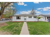 Charming single-story home with a well-maintained lawn and inviting walkway under a bright blue, partly cloudy sky at 701 Emporia St, Aurora, CO 80010