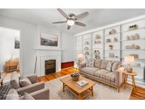 Cozy living room features built-in shelves, fireplace, ceiling fan and beautiful hardwood floors at 1137 N Sherman St # 16, Denver, CO 80203