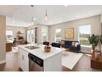 Bright open concept living room and kitchen with stainless steel appliances and hardwood floors at 2374 S University Blvd # 202, Denver, CO 80210