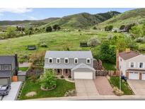 Charming two-story home with a well-maintained lawn and scenic views of rolling hills in the background at 225 Berthoud Way, Golden, CO 80401