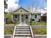 Charming home featuring a landscaped front yard with a wrought iron fence and a welcoming porch at 2074 S Emerson St, Denver, CO 80210
