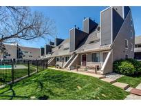 Townhouse exterior featuring well-maintained landscaping, gray-toned paint and black fence at 5250 S Huron Way # 10-207, Littleton, CO 80120