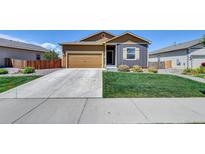 Charming home featuring a two-car garage, well-manicured lawn, and inviting curb appeal at 7433 Ellingwood Cir, Frederick, CO 80504