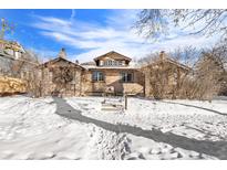 Inviting brick home with a dormer and chimney is surrounded by snow and bushes during the winter season at 2222-2224 Hooker St, Denver, CO 80211