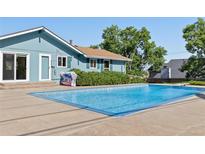 Refreshing blue swimming pool and patio area, perfect for outdoor relaxation and entertaining at 310 S Alkire St, Lakewood, CO 80228