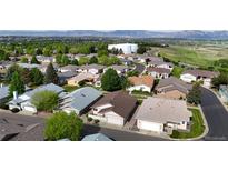 An aerial view of a well-maintained residential neighborhood with lush greenery and mountain views in the background at 23 Carla Way, Broomfield, CO 80020