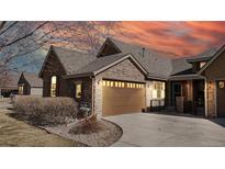 Charming home featuring a stone facade, a two-car garage, and well-maintained landscaping at 2238 Calais Dr # B, Longmont, CO 80504