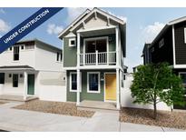 Charming two-story home with a yellow door and a balcony at 13079 E 103Rd Pl, Commerce City, CO 80022