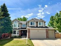 Charming two-story home features a two-car garage, beautiful lawn, and classic brick and siding accents at 11056 W Rowland Ave, Littleton, CO 80127