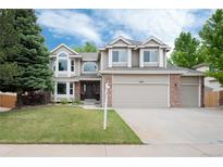 Charming two-story home featuring a three-car garage, manicured lawn, and mature landscaping at 11056 W Rowland Ave, Littleton, CO 80127