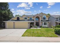 Inviting two-story home with a well-manicured lawn and attached three-car garage at 1762 Red Fox Pl, Highlands Ranch, CO 80126