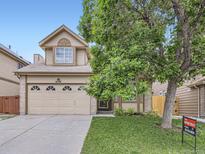 Charming two-story home with a well-maintained front yard and a two-car garage at 6154 Quitman St, Arvada, CO 80003