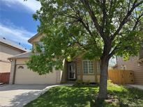 Charming two-story home with manicured lawn and mature shade tree in front at 6154 Quitman St, Arvada, CO 80003