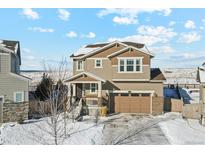 Two-story home boasts a neutral color palette, attached two-car garage, and snow-covered landscaping at 3375 Umber Cir, Castle Rock, CO 80109
