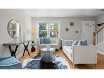 Bright living room boasts large windows, hardwood floors, and stylish modern furniture and decor at 2867 Jasmine St, Denver, CO 80207