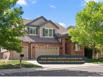 Two story home with brick and beige siding, three car garage, and mature trees at 11842 Altura St, Commerce City, CO 80603