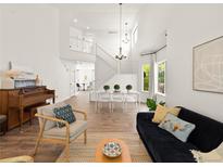 Bright, open living room with hardwood floors, modern furnishings, and large windows providing ample natural light at 11842 Altura St, Commerce City, CO 80603