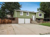 Charming home with a two-car garage, front yard and mature trees at 11805 W 74Th Ave, Arvada, CO 80005