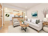 Bright living room featuring an open floor plan, modern furnishings, and hardwood floors at 5995 W Hampden Ave # 3E, Denver, CO 80227