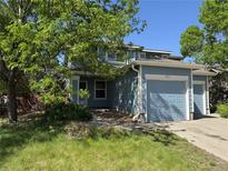 Charming two-story home featuring an attached two-car garage and a well-maintained front yard at 897 Mockingbird Ln, Brighton, CO 80601