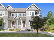 Charming two-story townhome with a covered front porch and gray siding at 1678 Wright Aly, Erie, CO 80516