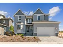 Charming two-story home featuring gray siding, a two-car garage, and a well-manicured front yard at 890 Coal Bank Trl, Castle Rock, CO 80104